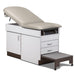 A medical examination table with drawers and patient step stool, country mist upholstery and gray base color