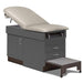A medical examination table with drawers and patient step stool, country mist upholstery and slate gray base color